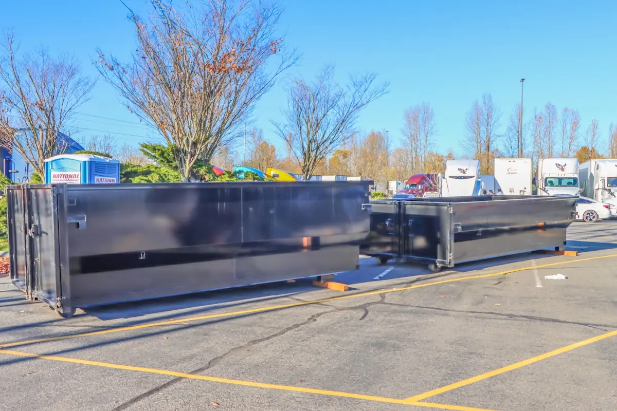 Professional dumpster rental service with roll-off container on residential driveway in Brush